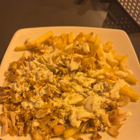 Plato de shawarma de pollo con patatas y salsa
